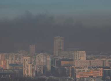 Residential buildings in Kyiv are seen through smoke from fires after shelling nearby