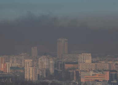 Residential buildings in Kyiv are seen through smoke from fires after shelling nearby
