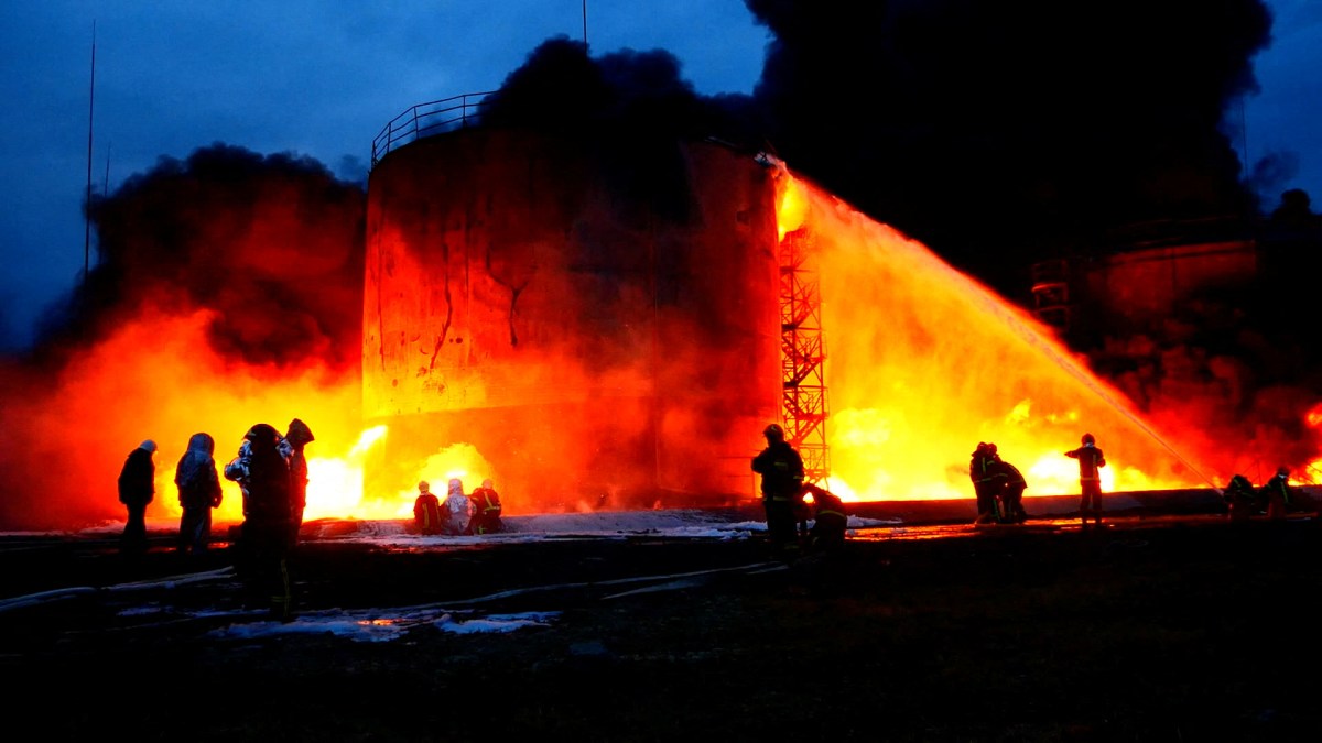 Rescuers work at a site of fuel storage facilities hit by cruise missiles in Lviv