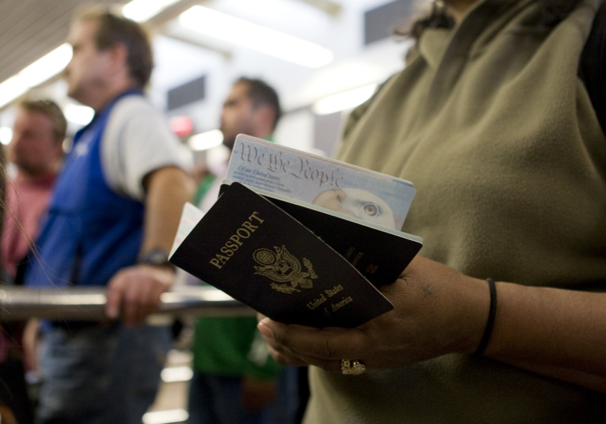 FILE PHOTO: A woman holds passports while waiting to cross at the San Ysidro border crossing