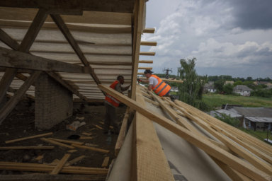 Ukrainians rebuilding a house