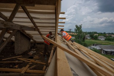 Ukrainians rebuilding a house
