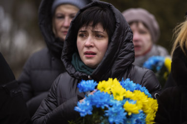A woman cries during a memorial service to mark the one-year anniversary of the start of the Russia Ukraine war