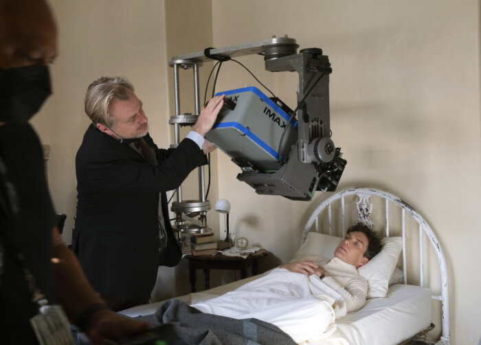 This image released by Universal Picture shows filmmaker Christopher Nolan working with an IMAX camera on the set with actor Cillian Murphy during the filming of "Oppenheimer."