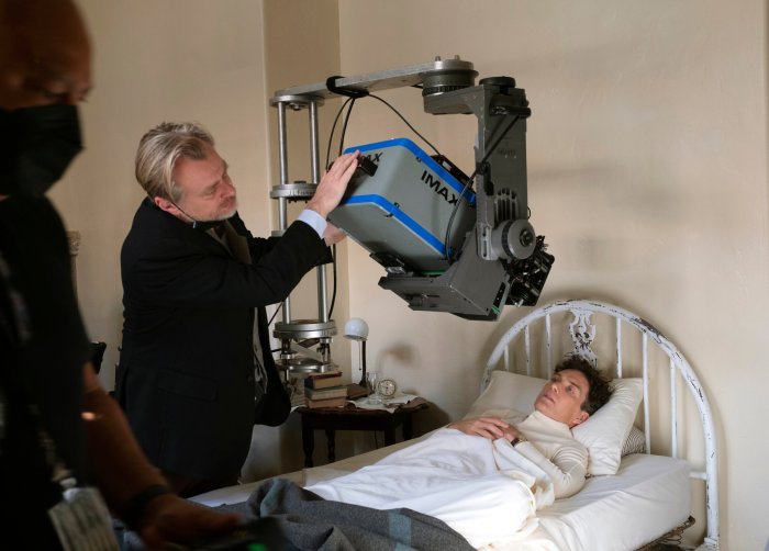 This image released by Universal Picture shows filmmaker Christopher Nolan working with an IMAX camera on the set with actor Cillian Murphy during the filming of "Oppenheimer."