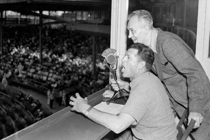 FILE - Baseballer Charlie Grimm,left, deposed by the Chicago Cubs in favor of Gabby Hartnett as manager, takes up new duties as a radio broadcaster at the ball games at Wrigley Field in Chicago, July 25, 1938. He's assisted by Pat Flanagan, a broadcasting colleague. Many baseball fans, especially older ones, originally fell in love with America’s pastime by listening to ballgames on AM radio. But several major automakers are eliminating broadcast AM radio from newer models, prompting lawmakers on Capitol Hill to propose legislation that would prevent the practice for safety and other reasons.